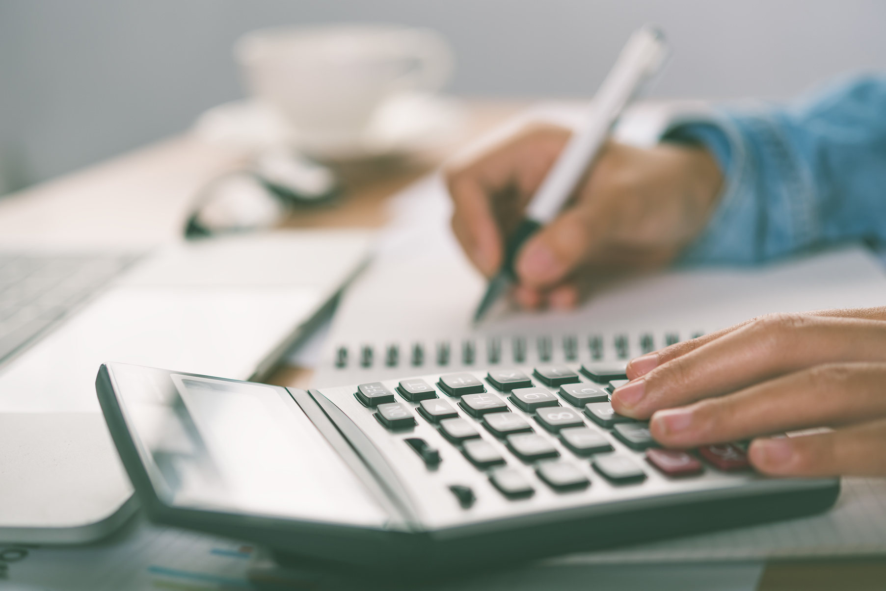 Hands Using Calculator with Pen for Cost Analysis